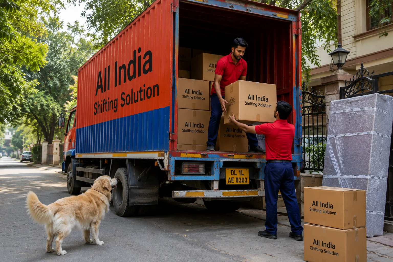 A friendly family dog watching curiously as movers efficiently load corrugated cardboard boxes professionally printed with "All India Shifting Solution" in black text into a plain red and blue Indian container truck with "All India Shifting Solution" in large black text parked in a quiet, leafy residential lane.